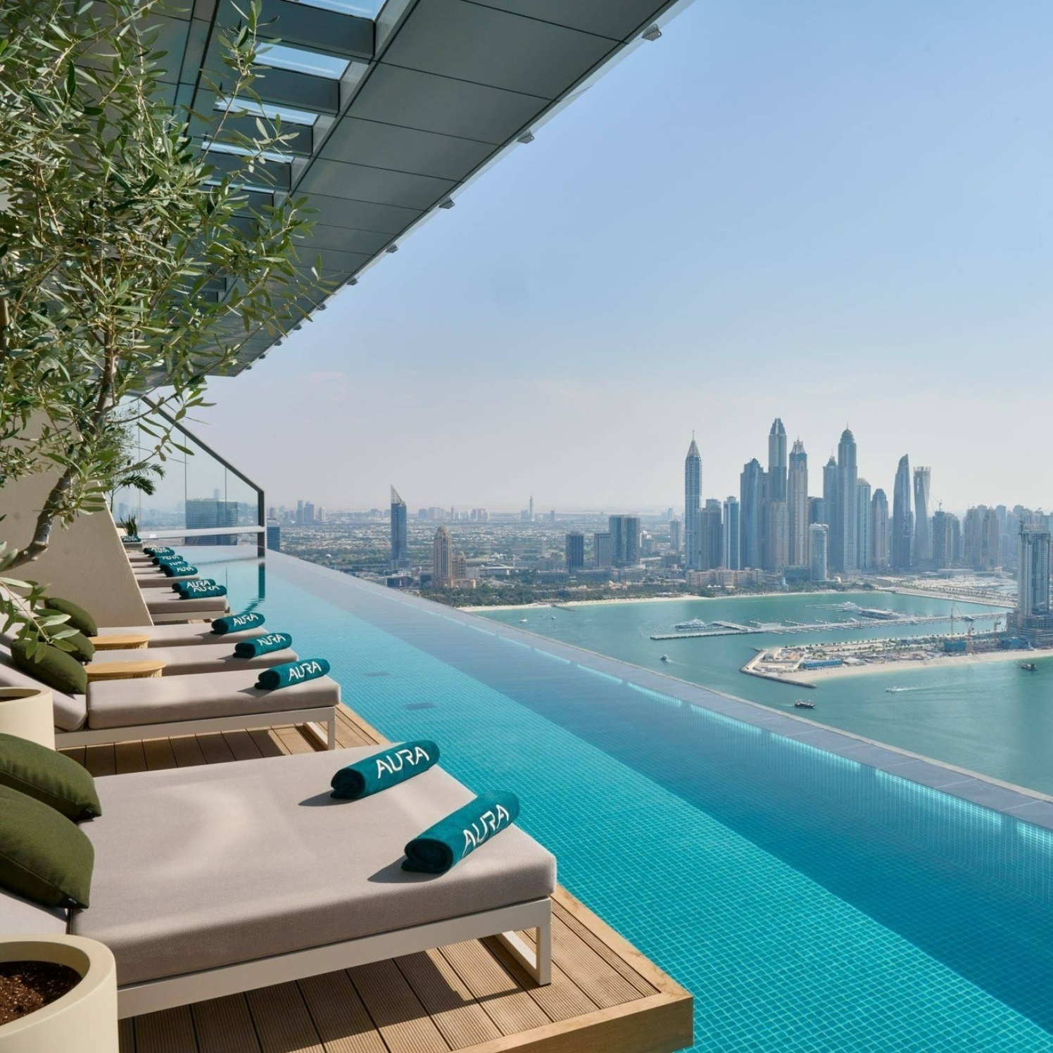 Rooftop resort pool at sunset with lounge seats