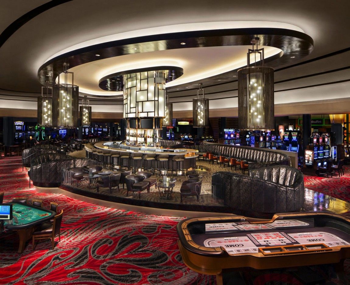Well-lit casino floor with organized table layout and visible staff